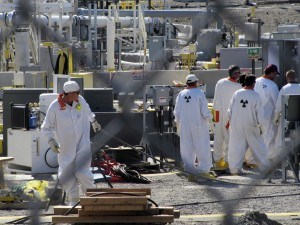 FILE - In this July 14, 2010 photo, workers at the Hanford nuclear reservation work around a a tank farm where highly radioactive waste is stored underground near Richland, Wash. Six underground radioactive waste tanks at the nation's most contaminated nuclear site are leaking, Gov. Jay Inslee said Friday, Feb. 22, 2013. Inslee made the announcement after meeting with federal officials in Washington, D.C. Last week it was revealed that one of the 177 tanks at south-central Washington's Hanford Nuclear Reservation was leaking liquids. Inslee called the latest news "disturbing." (AP Photo/Shannon Dininny, File)